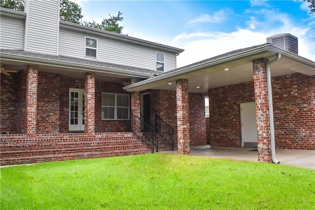 6613 Memphis St, New Orleans, LA 70124 - rear view of property featuring a chimney, a lawn, brick siding, central air condition unit, and a patio area