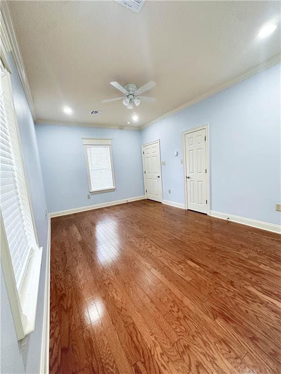 empty room with ceiling fan, hardwood / wood-style floors, and crown molding