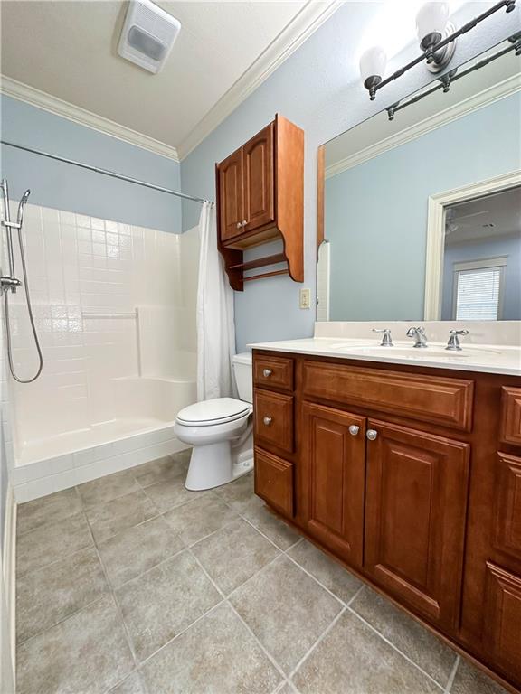 bathroom with ornamental molding, vanity, toilet, and a shower with shower curtain