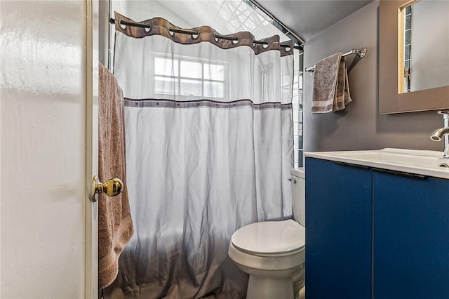 bathroom with walk in shower, vanity, and toilet