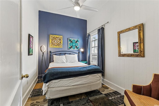 bedroom featuring baseboards, stone finish flooring, and ceiling fan