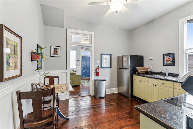 kitchen featuring freestanding refrigerator, dark countertops, cream cabinets, and ceiling fan