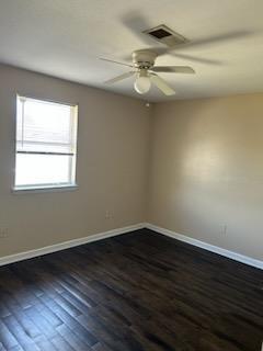 unfurnished room with ceiling fan and dark wood-type flooring