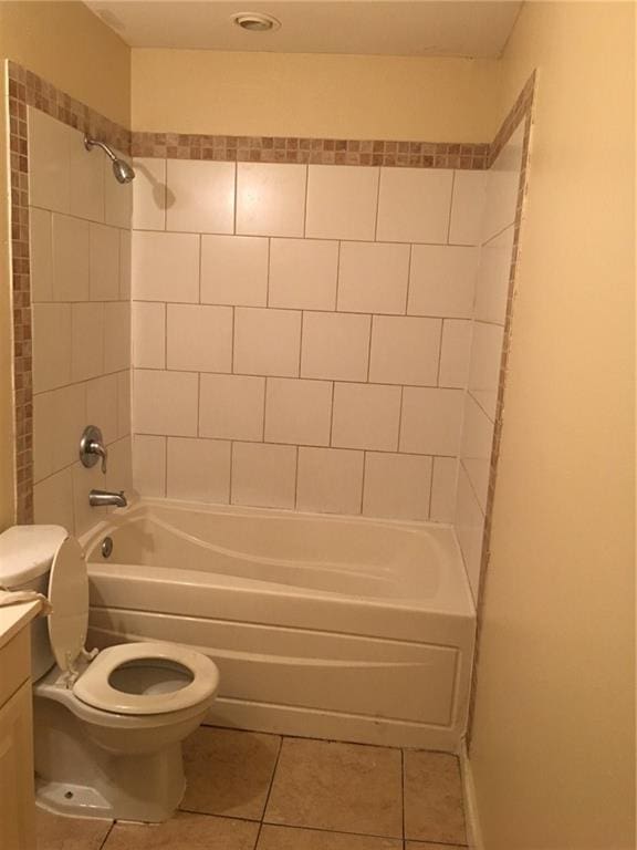 full bathroom featuring tile patterned flooring, vanity, tiled shower / bath combo, and toilet