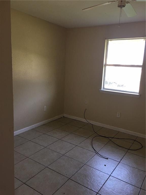 empty room featuring light tile patterned floors and ceiling fan