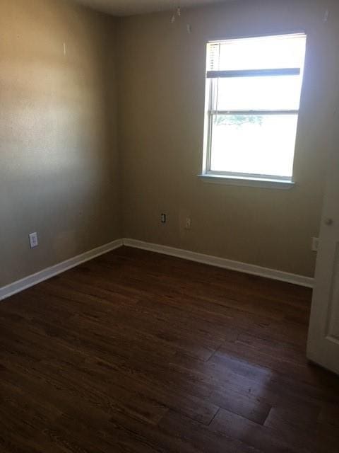 spare room with dark hardwood / wood-style flooring