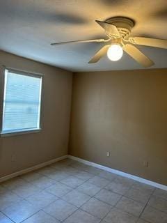 tiled empty room featuring ceiling fan