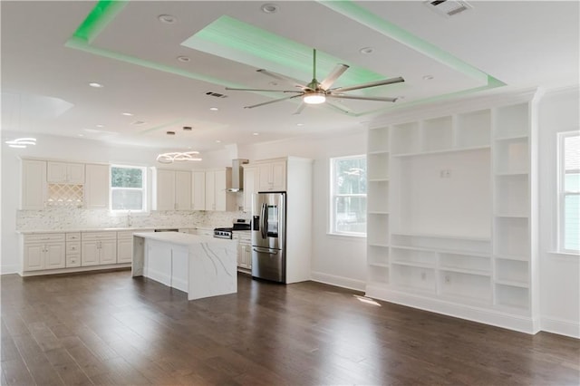 kitchen featuring dark hardwood / wood-style floors, white cabinets, a kitchen island, stainless steel appliances, and ceiling fan