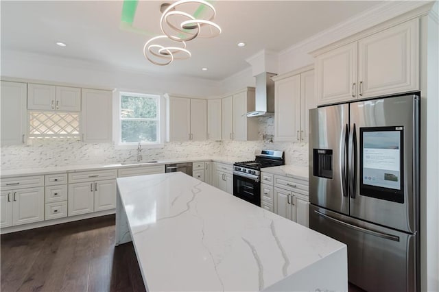 kitchen with appliances with stainless steel finishes, light stone countertops, dark hardwood / wood-style flooring, decorative light fixtures, and wall chimney range hood