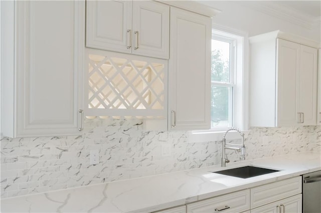 kitchen with dishwasher, light stone countertops, sink, and white cabinetry