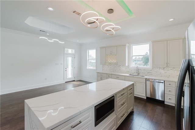 kitchen featuring stainless steel appliances, hanging light fixtures, dark hardwood / wood-style floors, and plenty of natural light