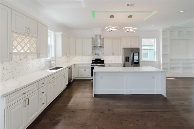 kitchen with dark hardwood / wood-style floors, sink, wall chimney range hood, and stainless steel appliances