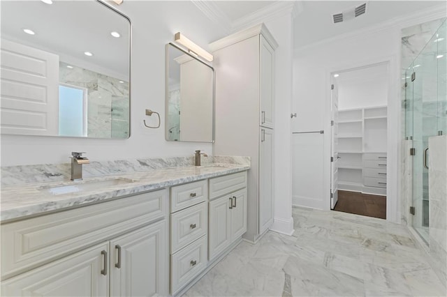 bathroom with vanity, crown molding, and a shower with door