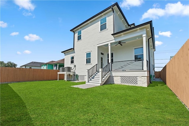 back of property featuring ceiling fan and a yard