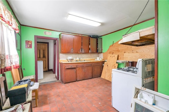 kitchen featuring sink, ornamental molding, white gas range oven, washer / dryer, and decorative backsplash