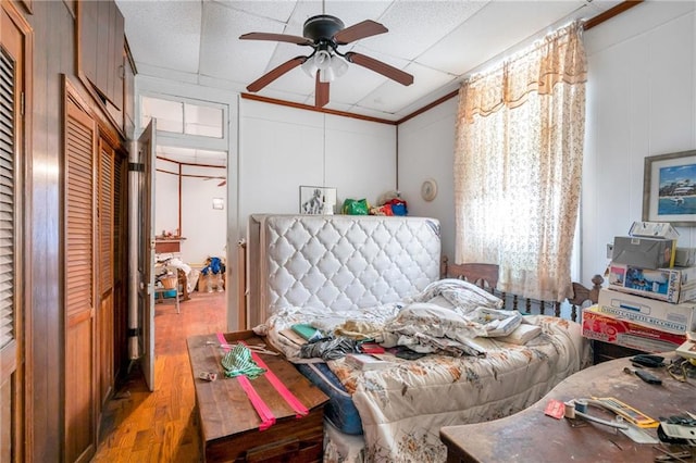 bedroom featuring ornamental molding, light hardwood / wood-style floors, and ceiling fan