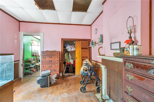 miscellaneous room featuring light hardwood / wood-style floors, a paneled ceiling, and crown molding