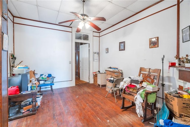 miscellaneous room featuring ceiling fan, a drop ceiling, and wood-type flooring