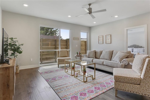 living room with ceiling fan and dark wood-type flooring