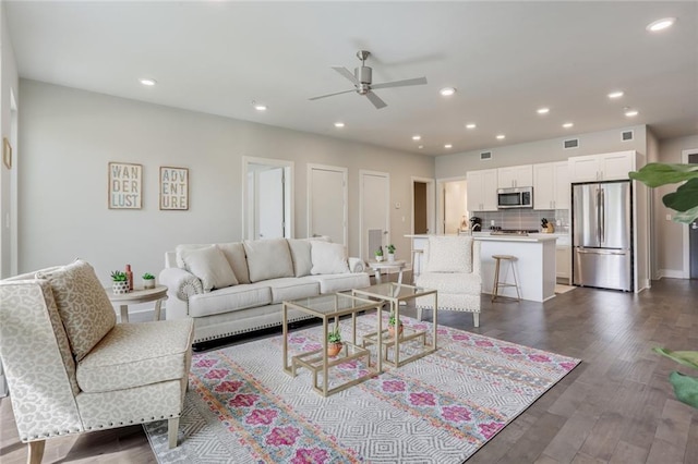 living room with ceiling fan and dark wood-type flooring