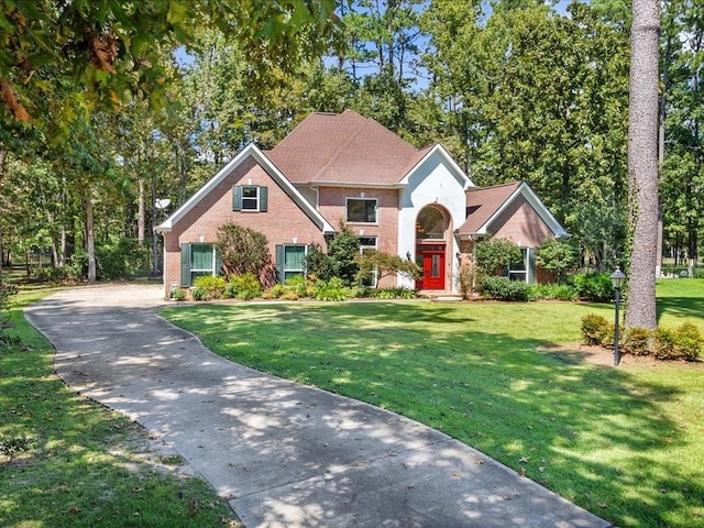 traditional-style house featuring brick siding and a front lawn