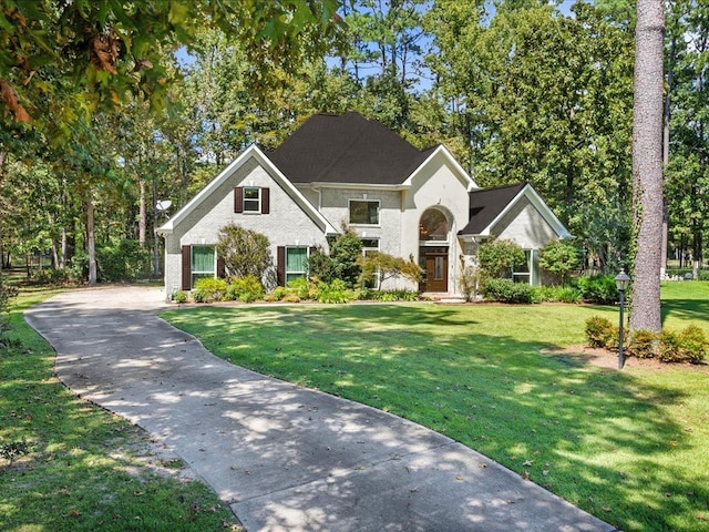 view of front of house featuring brick siding and a front lawn