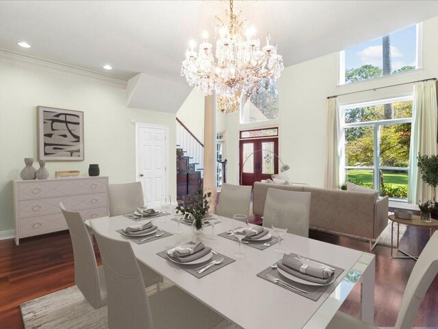 dining area with hardwood / wood-style flooring, plenty of natural light, crown molding, and a notable chandelier