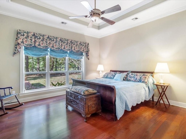 bedroom featuring crown molding, dark hardwood / wood-style floors, a raised ceiling, and ceiling fan