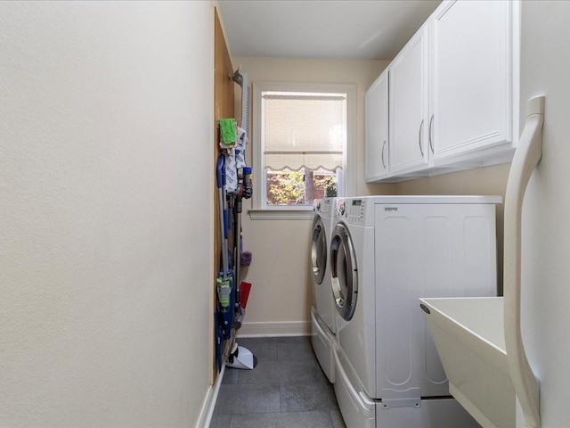 laundry area featuring cabinets, washing machine and clothes dryer, sink, and dark tile patterned floors