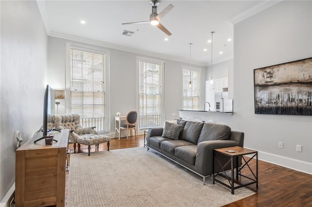 living room with ceiling fan, sink, crown molding, and hardwood / wood-style floors