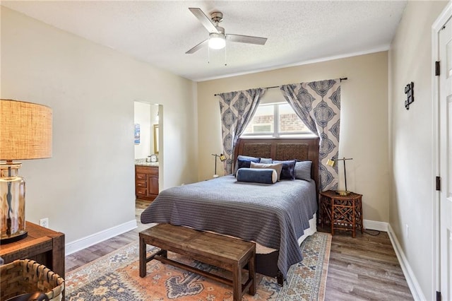 bedroom with wood-type flooring, ensuite bath, ceiling fan, and a textured ceiling