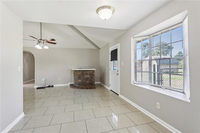 tiled foyer featuring lofted ceiling, a fireplace, and ceiling fan