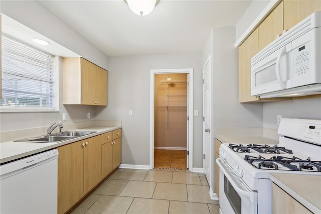 kitchen featuring light tile patterned floors, light brown cabinets, sink, and white appliances