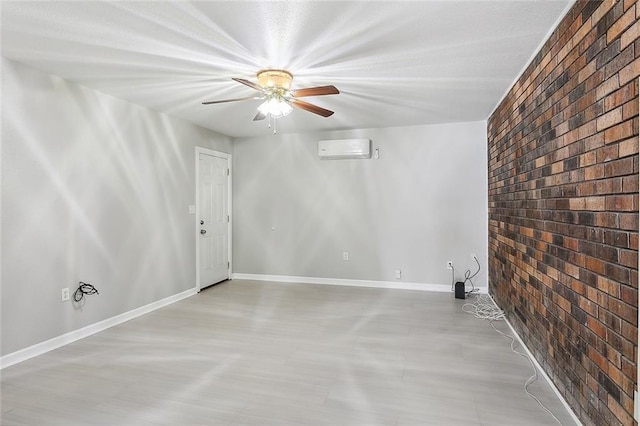 unfurnished room featuring an AC wall unit, ceiling fan, and brick wall