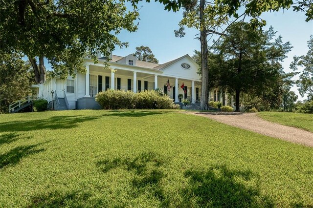 neoclassical home with a front yard and covered porch