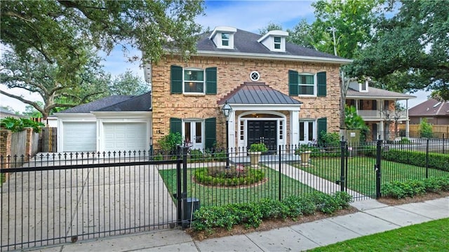 colonial house with a garage, driveway, a fenced front yard, a front lawn, and brick siding