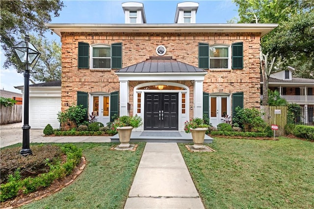 view of front of home featuring french doors, a front lawn, and brick siding