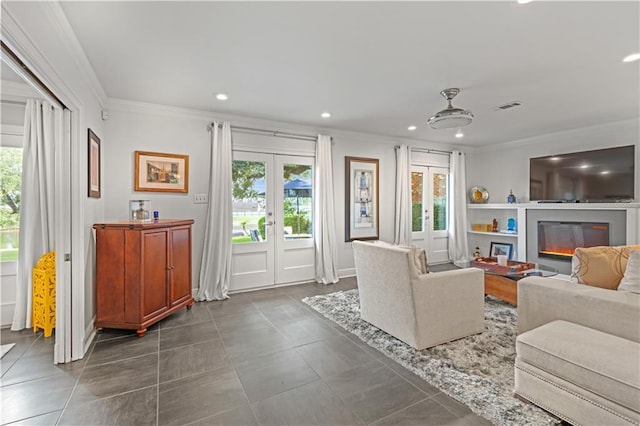 living area featuring visible vents, a glass covered fireplace, crown molding, french doors, and recessed lighting