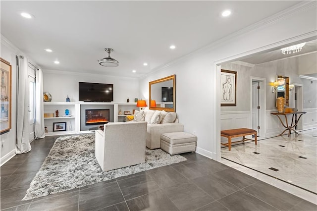 living area with crown molding, recessed lighting, a glass covered fireplace, and a decorative wall