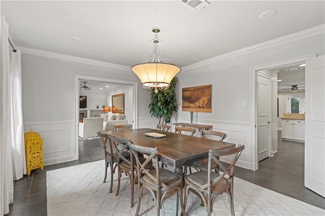 dining space featuring a decorative wall, visible vents, ornamental molding, and wainscoting