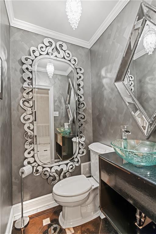 bathroom with an inviting chandelier, crown molding, and a sink