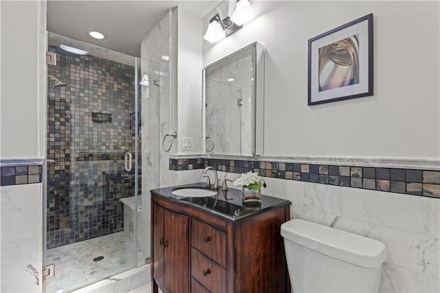 full bathroom with toilet, a stall shower, tile walls, and vanity