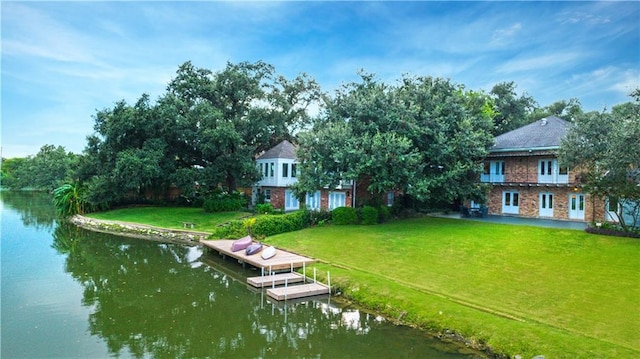 dock area featuring a water view and a lawn