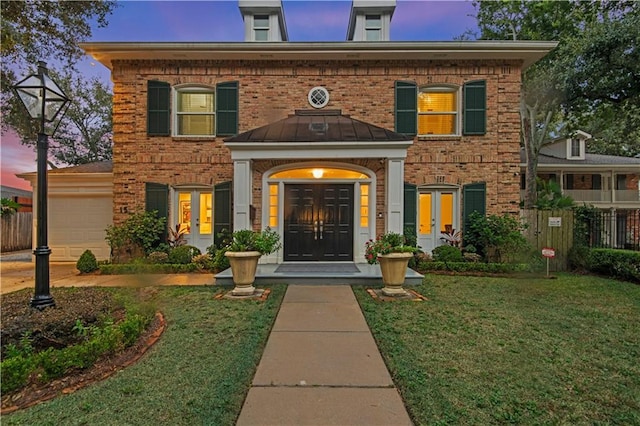 view of front of house with a garage, brick siding, and french doors