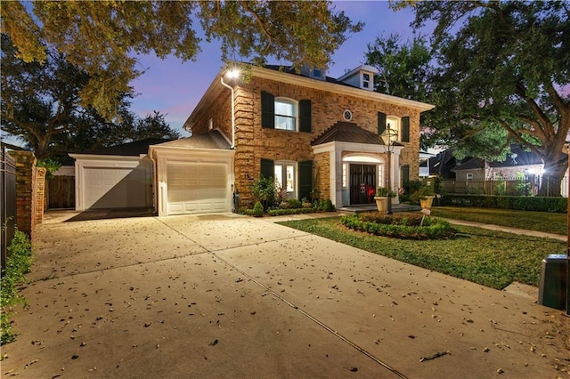 view of front facade with driveway, an attached garage, and fence