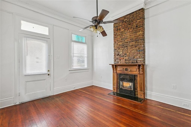 unfurnished living room featuring ceiling fan, crown molding, dark wood-type flooring, and a large fireplace