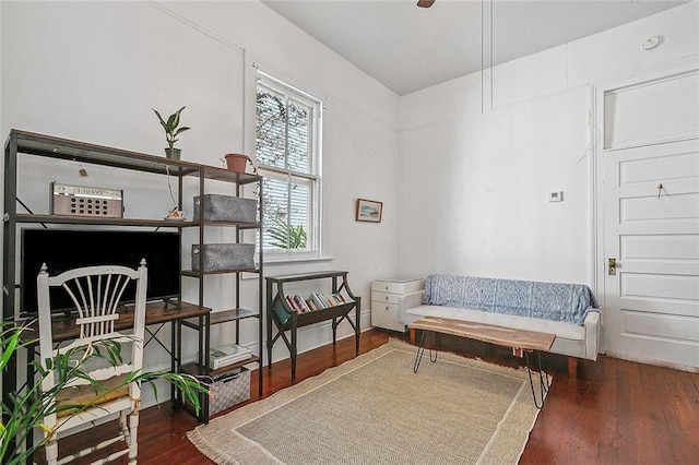 living area with ceiling fan and dark hardwood / wood-style flooring