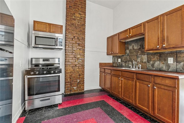 kitchen with decorative backsplash, a towering ceiling, sink, and stainless steel appliances