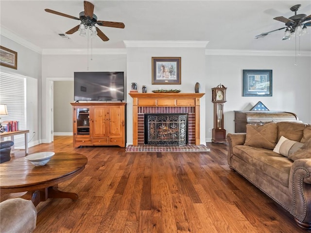 living room with wood-type flooring, ceiling fan, and a brick fireplace