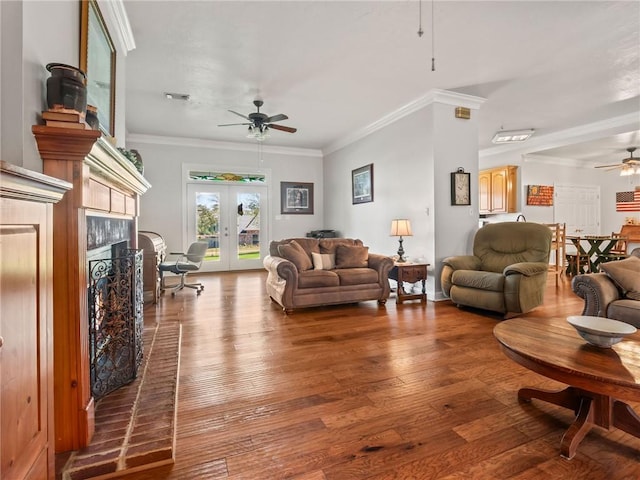 living room with a fireplace, crown molding, ceiling fan, french doors, and hardwood / wood-style floors